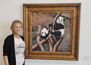 Freida standing by her Panda paintings